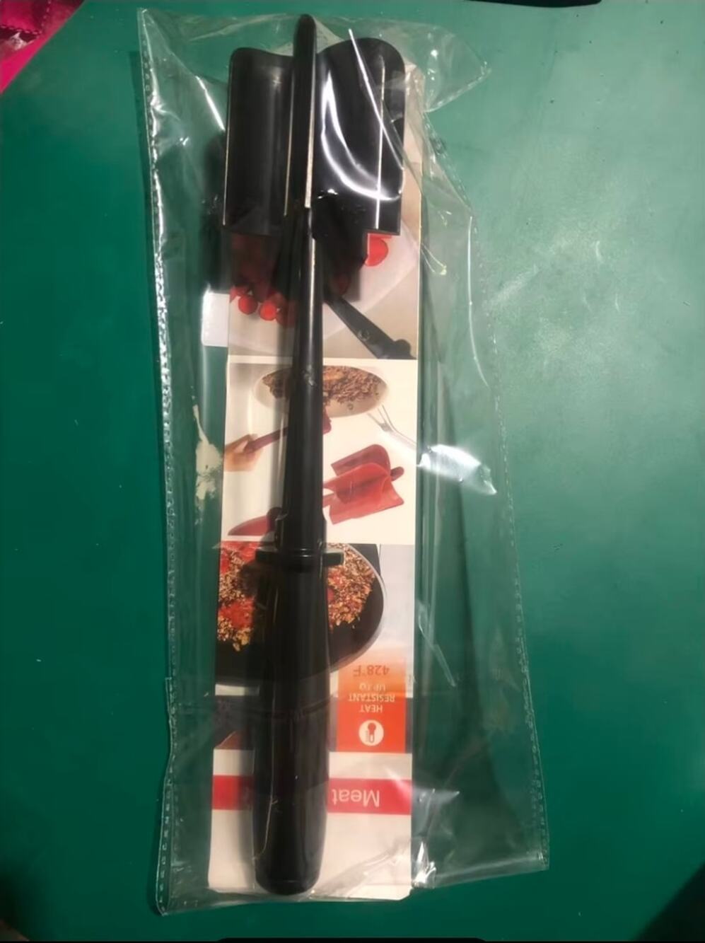 Black handheld meat and potato masher with multi-blade head